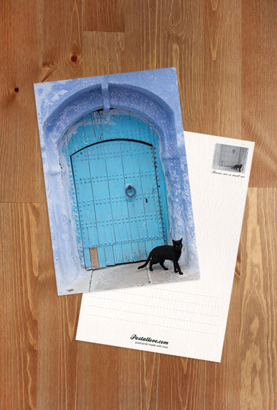 Blaue Tür und schwarze Katze
