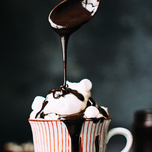 Eine gestreifte Tasse mit heißer Schokolade und Marshmallows