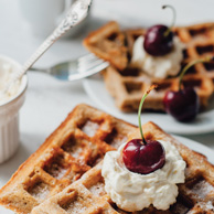 Waffeln mit Schlagsahne und Kirschen