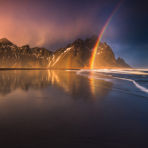 Regenbogen an einem Strand in Stokness, Island
